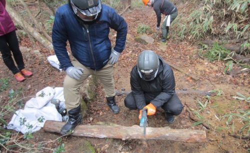 登山道整備の様子。細い丸太を切る様子の写真