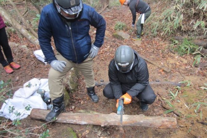 登山道整備の様子。細い丸太を切る様子の写真